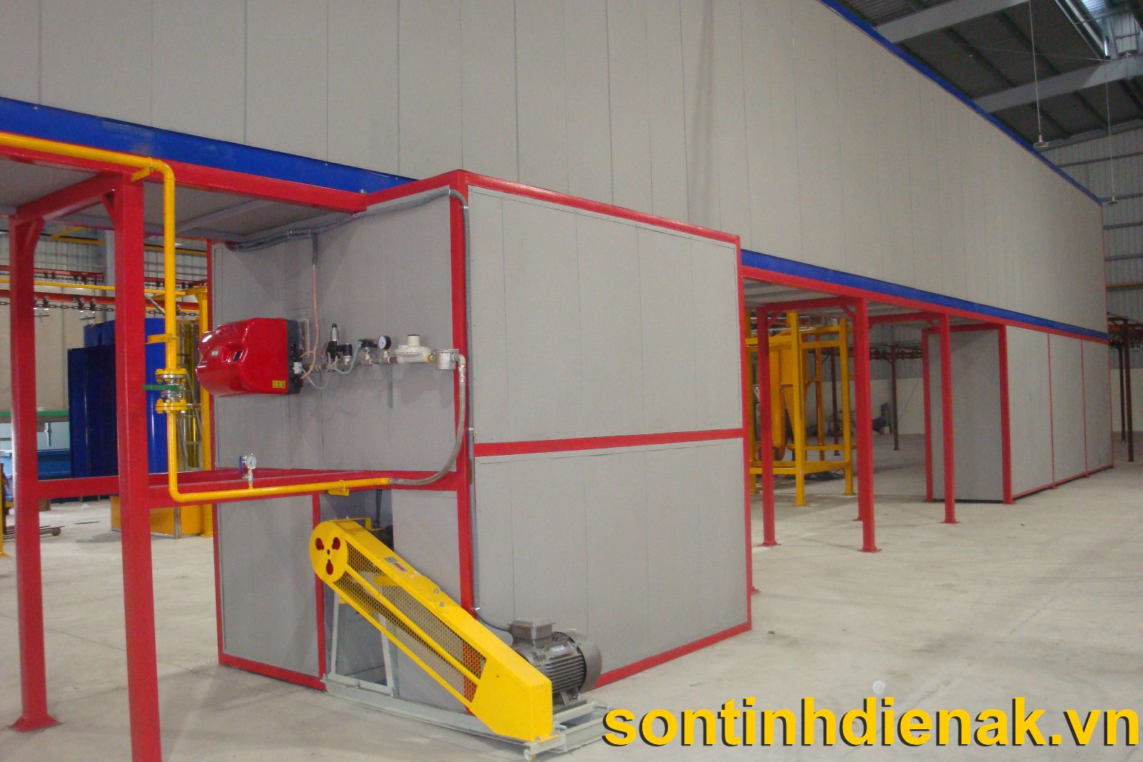 Đầu đốt gas và cụm van cấp gas gắn trên vách lò sấy sơn tĩnh điện, phía dưới là quạt tuần hoàn dẫn động bằng dây đai