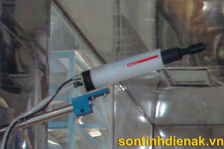 Cận cảnh một súng phun sơn tĩnh điện tự động gắn trên giá đỡ bên trong buồng phun vách kính