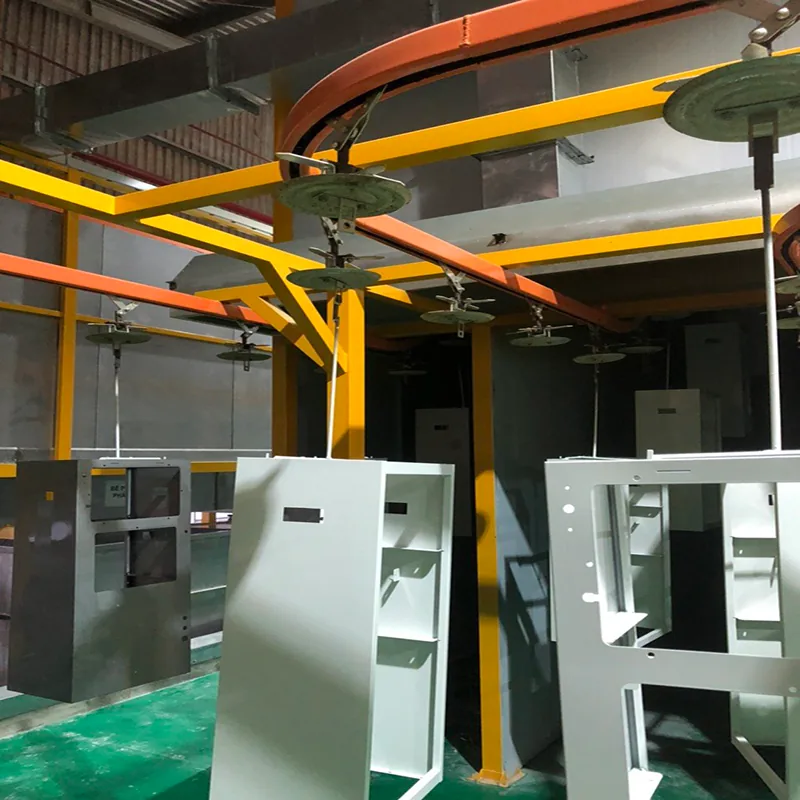 Khung tủ kim loại sơn trắng treo dưới các mâm treo, ray xích tải màu cam uốn cong trên khung thép vàng trong nhà xưởng